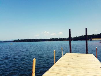 Pier over calm sea against blue sky