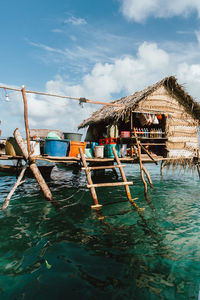Fishing boats moored in sea against sky
