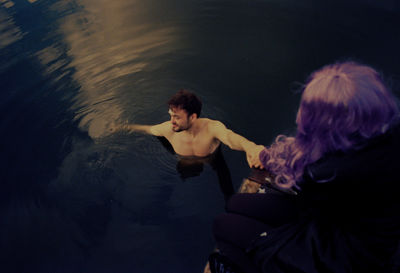 Rear view of woman sitting in sea