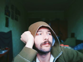 Man in hooded shirt at home