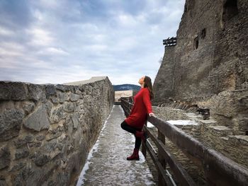 Rear view of woman walking on wall