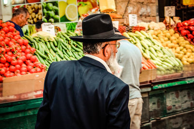 Rear view of man in traditional clothing at store