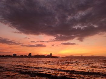 Scenic view of sea against dramatic sky during sunset