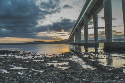 Bridge over sea against sky during sunset