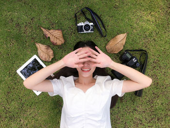 High angle view of young woman lying on grass