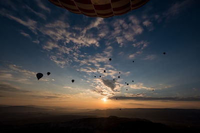 Low angle view of hot air balloons against sky during sunrise