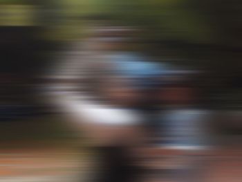 Blurred motion of man standing on street in city