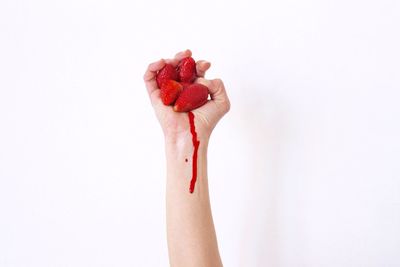 Close-up of hand holding over white background