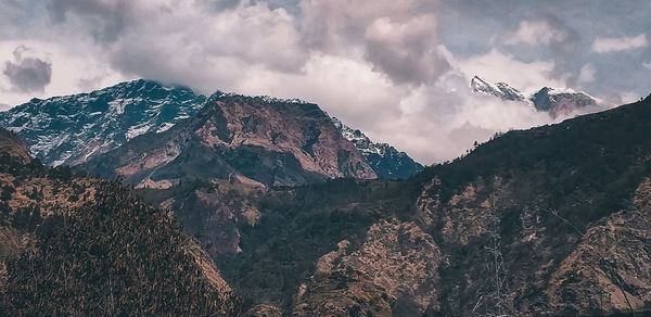 Low angle view of snowcapped mountains against sky