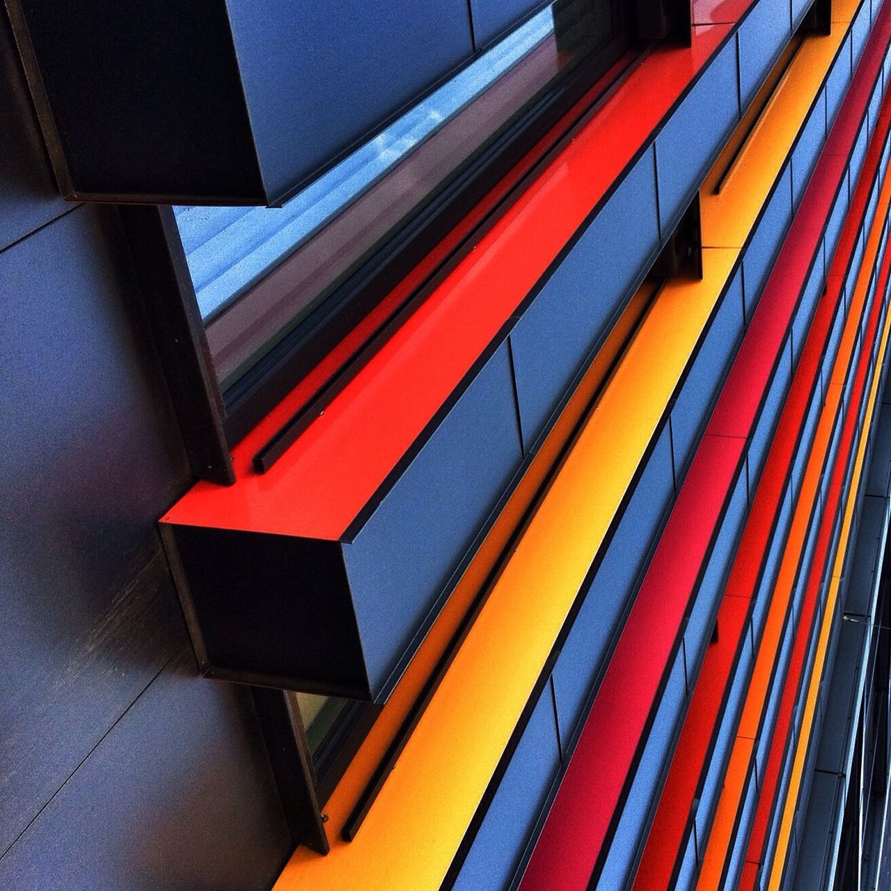 indoors, multi colored, illuminated, steps and staircases, low angle view, ceiling, built structure, architecture, pattern, red, steps, staircase, in a row, wall - building feature, colorful, no people, escalator, yellow, railing, subway station