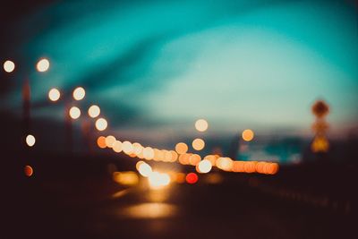 Defocused image of illuminated lights in city at night