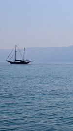Sailboat sailing on sea against clear sky