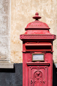 Close-up of red mailbox on wall