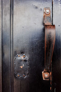 Close-up of rusty metal hanging on door