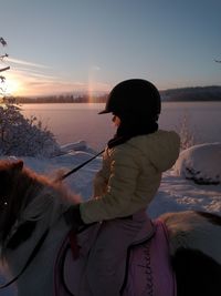 Woman on shore against sky during winter