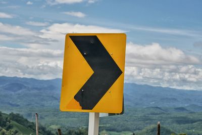 Close-up of road sign against mountain