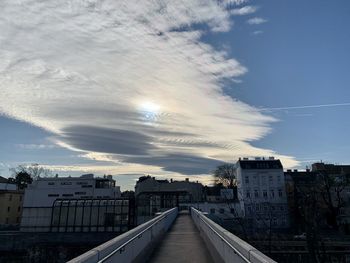 Road amidst buildings in city against sky