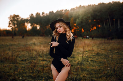 Young woman wearing hat while standing on field