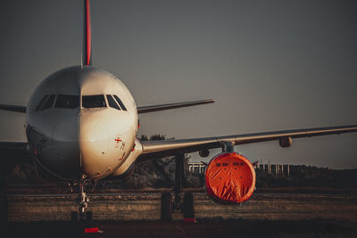 Close-up of airplane on runway against sky