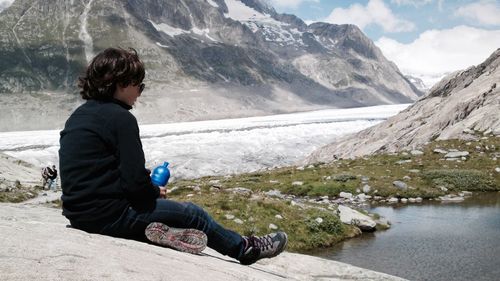 Pre-adolescent boy sitting on mountain at aletsch glacier