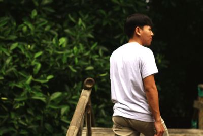 Rear view of man standing walking on footbridge