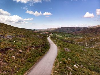 Road leading towards mountain against sky