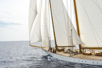 Sailboat sailing on sea against sky