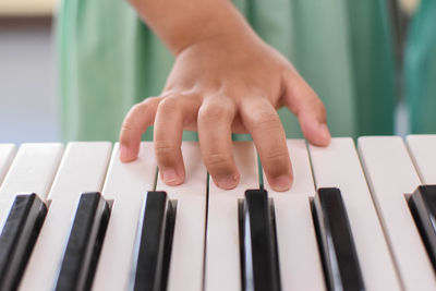 Cropped hand of child playing piano