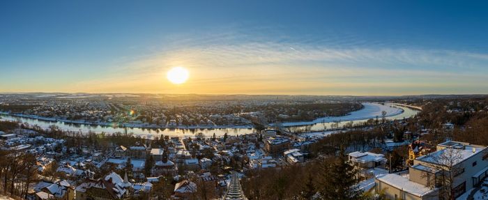 Scenic view of snow covered field against sky during sunset