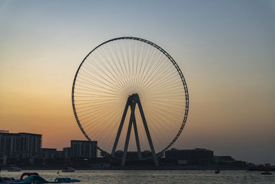 Ferris wheel in city at sunset