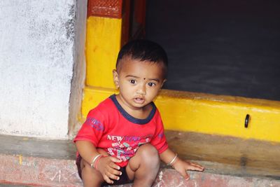 Portrait of cute boy sitting outdoors