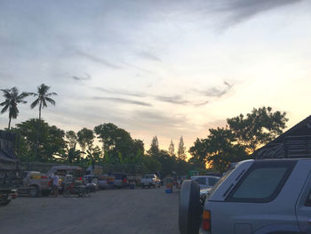 Cars on road against sky during sunset