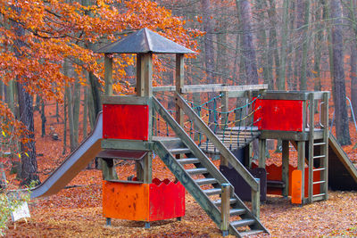 Red fire hydrant by trees in forest during autumn