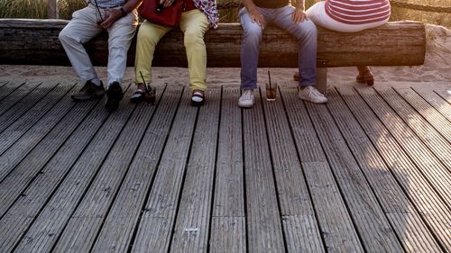 Low section of people standing on wooden floor