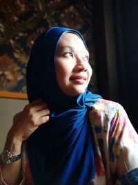 Close-up of thoughtful woman wearing hijab at home