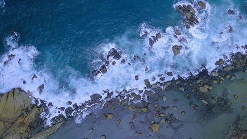 High angle view of waves splashing on shore