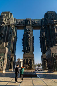 Rear view of people walking in front of historical building