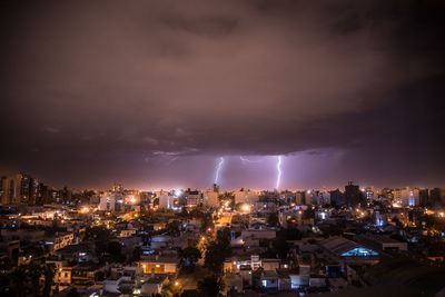 Illuminated cityscape against sky at night