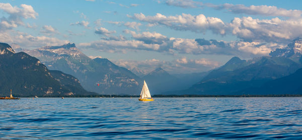 Boats in sea with mountains in background