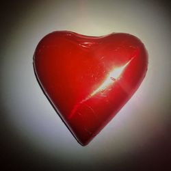 Close-up of red heart shape over white background