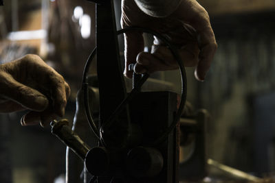 Cropped hands repairing machine part in workshop