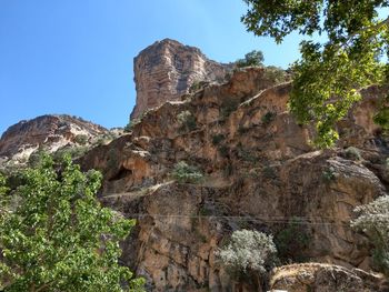 Low angle view of rocks on mountain against sky