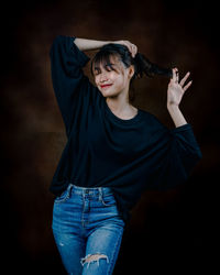 Rear view of woman standing against black background