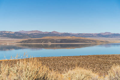 Scenic view of lake against clear blue sky