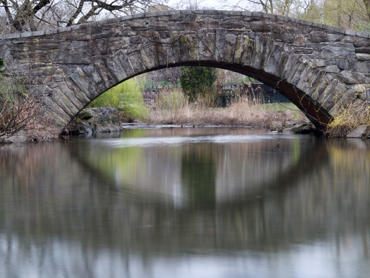 ARCH BRIDGE OVER RIVER BY TREES