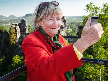 Portrait of woman standing on mobile phone