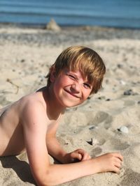 Portrait of happy boy on sand at beach