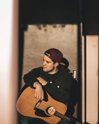 Man with guitar sitting at home