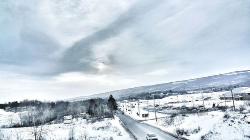 Tilt image of snow covered landscape against sky