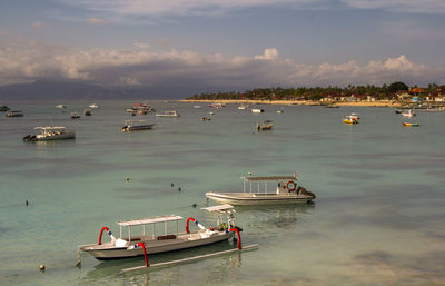 Boats moored on sea against sky